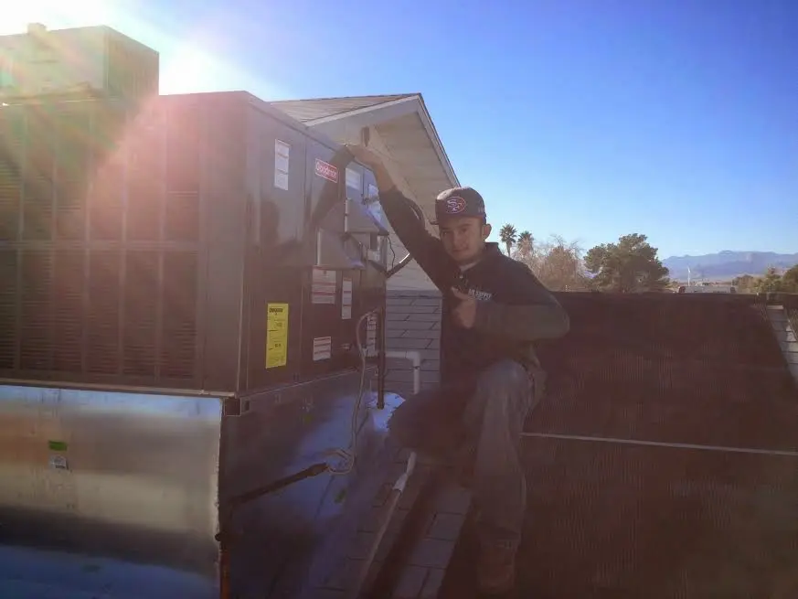 HVAC technician performing Boiler Repair on a rooftop unit in Rock Falls